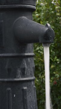 Close up of street column tap water stream vertical