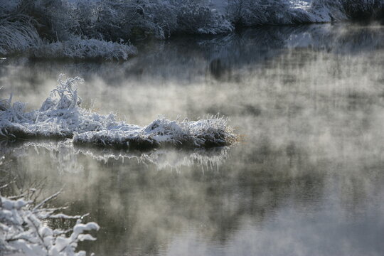 長野県飯綱高原、大座法師池の冬。水面を這う神秘的な気嵐と雪景色