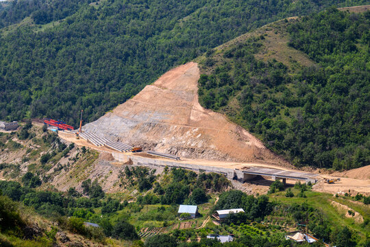Hillside construction with heavy machinery and exposed soil