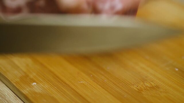 Macro shot of sharp knife slicing raw meat steak