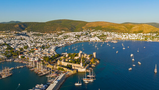 Bodrum, Turkey. Aerial view of Bodrum Castle fortress walls and towers with yachts in foreground, beaches and white houses in background.. Aerial View