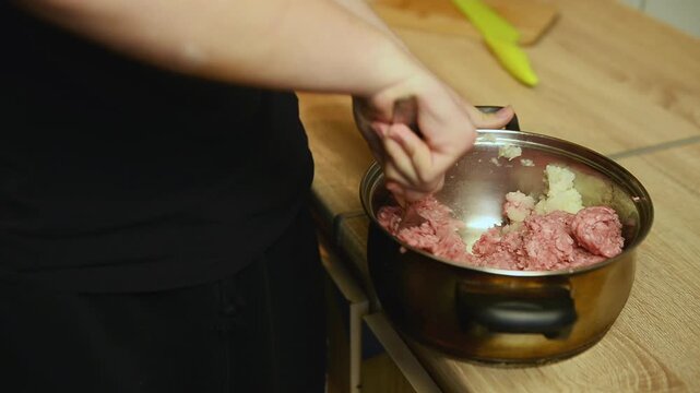 Mixing minced meat filling in metal pan close up