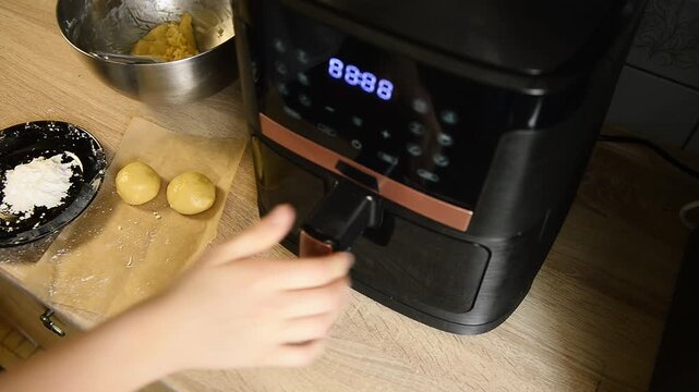 Placing sweet dough balls tray into air fryer oven
