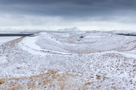 Snow covered caldera in the volcanic landscape of Lake Myvayn, Iceland. These geological craters are formed when a major eruption causes the volcano to collapse on itself.