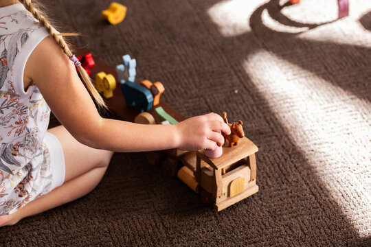 Imaginative play with kid playing indoors with wooden semi-trailer truck