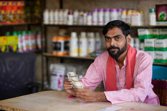 Indian fertilizer shop owner counting money