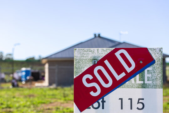 Land lot SOLD sign infront of house under construction