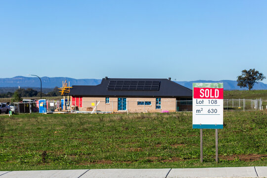 Land lot SOLD sign infront of house under construction