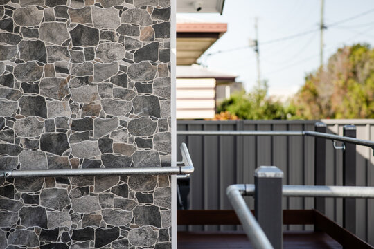 feature stone wall on the exterior of a building, with a ramp and railings