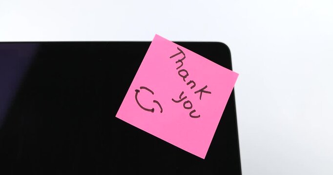 A pink sticky note displaying the handwritten message Thank You alongside a cute smiley face icon, representing gratitude and appreciation details.