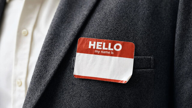 A close-up of a businessman's suit with a name tag attached