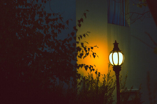 Vintage streetlamp glows warmly in the dark
