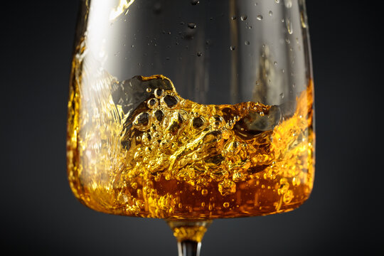 White wine of rich amber color being poured into a glass.