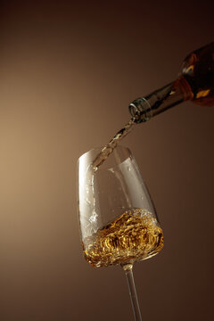 Pouring white wine from a bottle into a glass.