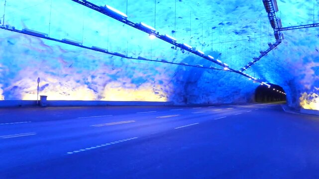 Cinematic 4K footage driving through L&aelig;rdal Tunnel in Norway, showcasing the impressive underground road infrastructure, illuminated tunnel sections and unique mountain engineering. Ideal for travel.