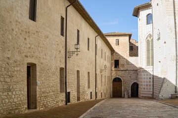 Fototapeta premium Quiet medieval courtyard by the Basilica of Saint Clare with historic stone walls in Assisi, Italy.