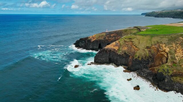 Scenic volcanic coast with dark basalt formations, ocean caves and breaking waves on Sao Miguel island, Azores