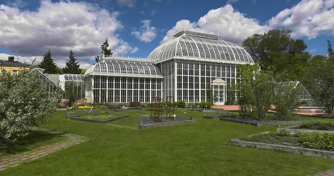 Historic wrought-iron glasshouses of the Palm House within the Kaisaniemi Botanical Garden, located in central Helsinki in cloudy spring weather, Helsinki, finland, Europe.