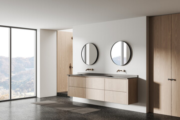 Naklejka premium Minimalist bathroom interior featuring floating wooden vanity, dual circular mirrors, terrazzo floor and large window overlooking serene landscape. 3D Rendering