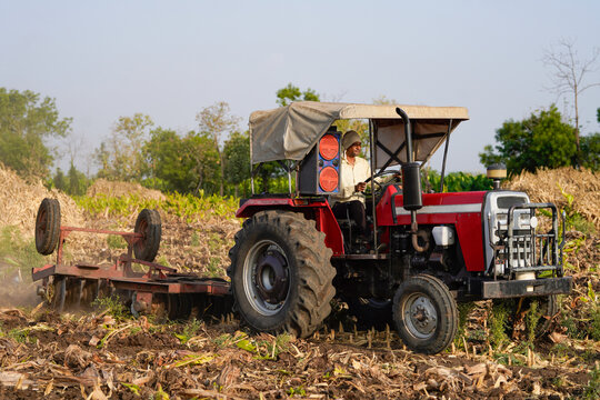 Indian farmer working with tractor at agriculture field
