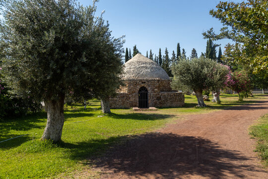Traditional Yoruk stone cistern for rainwater collection in olive grove at Dokumapark. Historical water storage structure for irrigation in Mediterranean city of Antalya, Turkey on summer day.