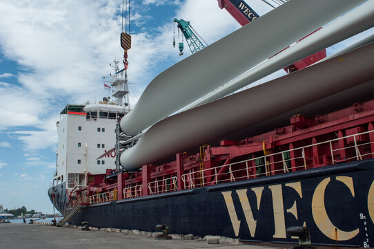 The process of unloading wind farm blades from a cargo ship in Indonesia.