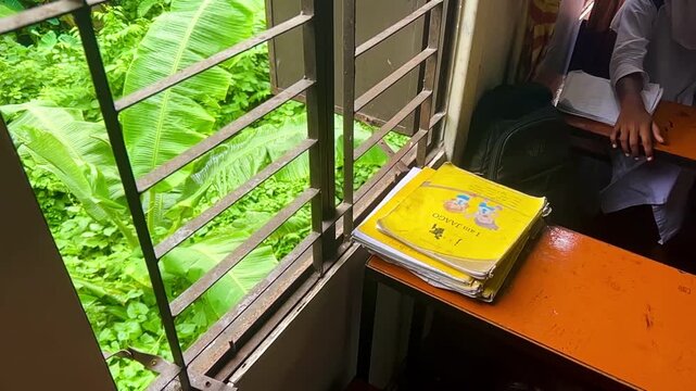 High Bench with a Stack of Yellow Notebooks Inside a Bright School Classroom