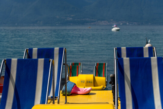 Blaue Liegest&uuml;hle auf gelbem Tretboot am See