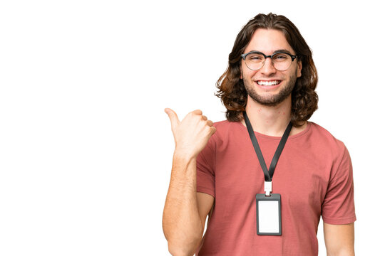Young handsome man with ID card over isolated background pointing to the side to present a product