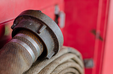 A fire hose coupling and hose assembly stored inside a fire station cabinet on board an offshore support vessel. The fire hose forms part of the vessel's fixed fire-fighting system © Vitaliy