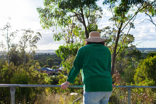 young woman leaning on handrail looking over landscape towards town of Glen Innes