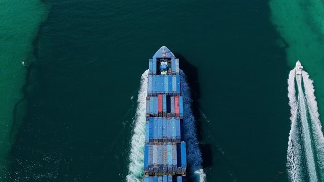 Aerial view cargo ship entering harbor. Cargo business. Container ship. Shipping logistics. Commercial shipping. Cargo ship in sea, aerial view. Freight container loaded on cargo vessel, 4k