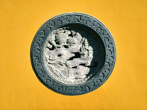 The yellow wall relief, characteristic East Asian architecture of an old temple (Faxi Temple, Hangzhou, China)