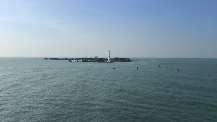Obraz premium a small island and a lighthouse in the middle of the bright blue ocean