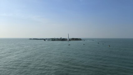 Obraz premium a small island and a lighthouse in the middle of the bright blue ocean