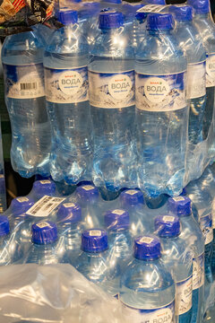 Plastic bottles of mineral water in shrink wrap packaging on supermarket shelf
