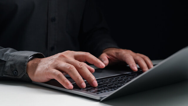 Close up of male hands typing on a laptop keyboard