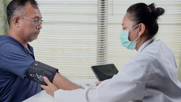 Doctor measuring blood pressure of a senior male patient