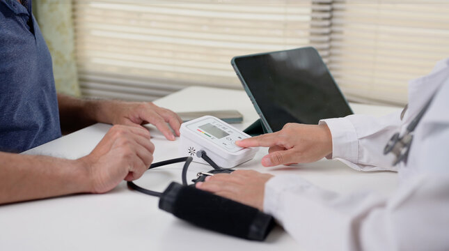 Doctor pressing the button of a blood pressure monitor