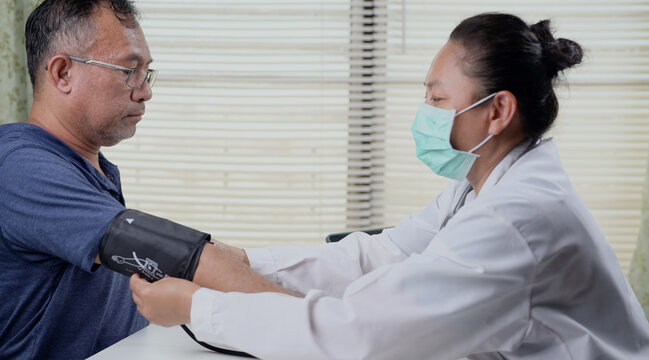 Health worker checking blood pressure of a senior man