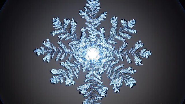 Beautiful symmetric snowflake crystal ice structure glowing with bright light on dark winter background macro