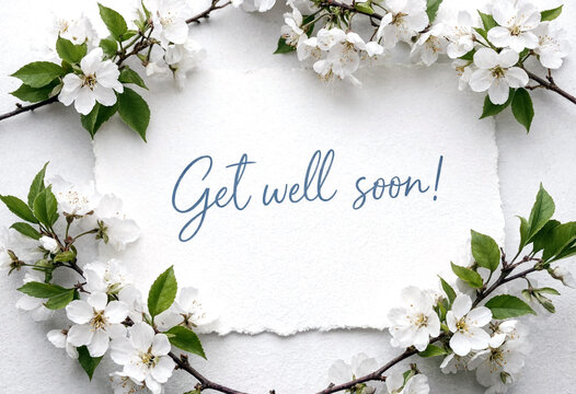 Beautiful white blossom flowers framing a get well soon message on paper card design