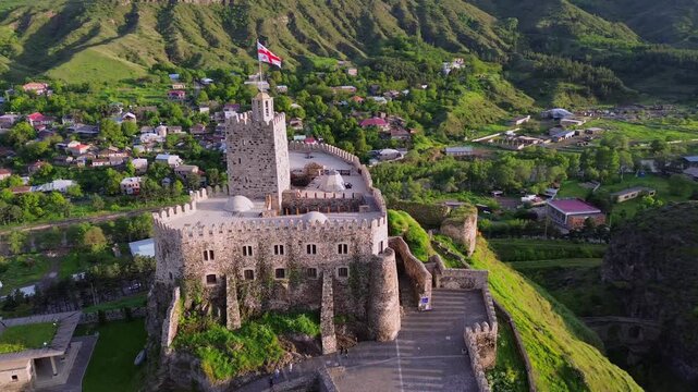 Aerial push in drone shot of medieval Rabati Castle fortress in Akhaltsikhe Georgia. Historic majestic tower architecture monument surrounded by green mountains nature during warm summer afternoon