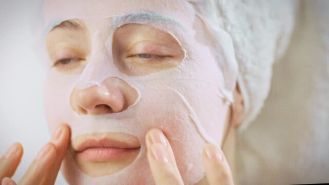 Bathroom mirror reflects young woman's gentle hands as she applies soothing aloe vera mask, embodying modern at-home skincare routine that prioritizes hydration nourishment for healthy, glowing skin