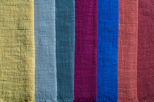Assortment of multi colored organic linen or cotton textile swatches arranged in vertical lines, closeup. Canvas woven material fabric palette background for fashion design tailoring or home decor