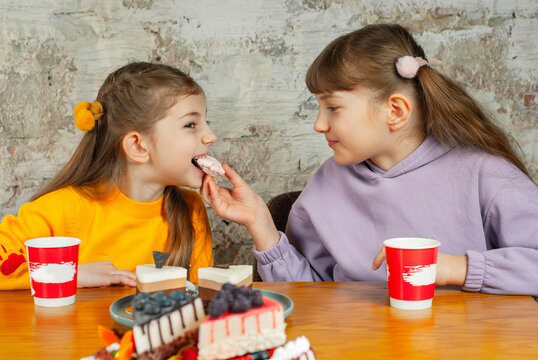 Girls share dessert at a table with sweet treats in a casual setting during afternoon gathering
