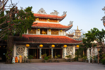 Obraz premium Chua Tan Thai Pagoda in Danang, Vietnam. Facade is decorated with golden bas-reliefs, lanterns, traditional Chinese characters and columns with mythical dragons