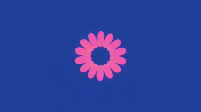 Abstract floral mandala forming with gentle rotation against a deep blue background in soft studio lighting