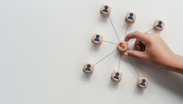 Hands holding wood cube with empathy leadership icon. symbolizing supportive management, trust building, human centered teamwork, workplace connection for corporate use. Empathy in leadership concept