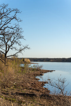 Still lake mirrors clear blue sky above